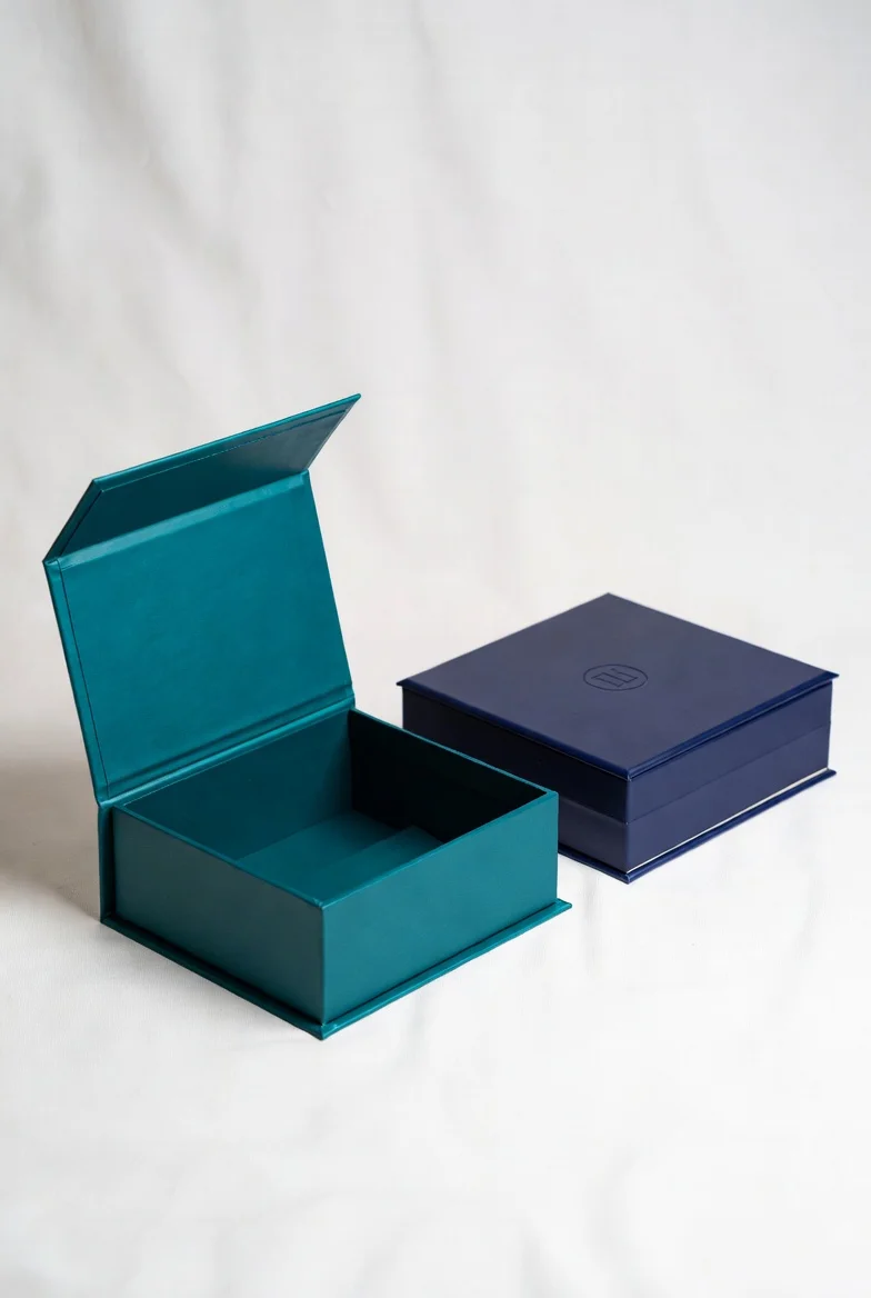 Magnetic flip top boxes in teal and navy blue showing secure magnetic closure and spacious interior for custom rigid packaging
