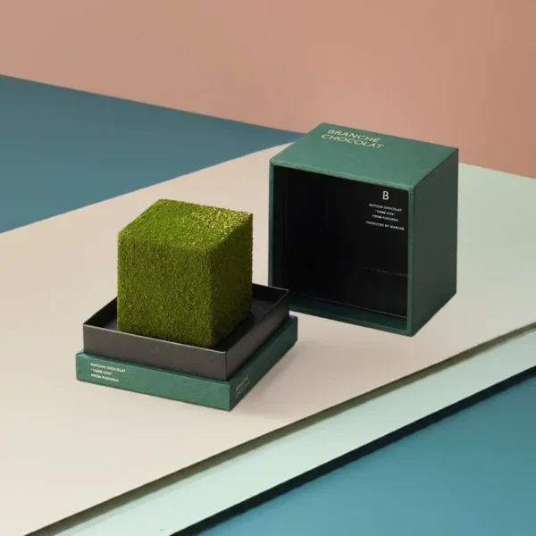 A luxury dark green shoulder rigid box featuring a custom "Branche Chocolat" logo and a square matcha cake displayed on the internal neck.